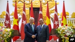 Perdana Menteri Turki Binali Yildirim (kiri), berjabat tangan dengan rekannya Vietnam Nguyen Xuan Phuc sebelum keduanya memulai pembicaraan tertutup di Hanoi, Vietnam, Rabu, 23 Agustus 2017. (Foto: Layanan Pers PM Turki via AP, Pool)