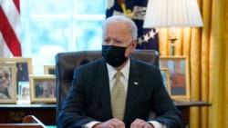 FILE - President Joe Biden is seen sitting at his desk in the Oval Office of the White House in Washington, March 30, 2021.