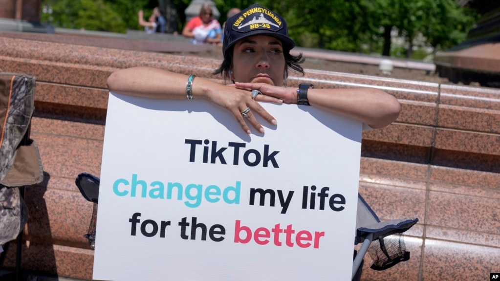 Una creadora de contenidos de TikTok, sostiene un cartel "TikTok cambió mi vida para bien" frente al Capitolio de EEUU, en Washington, el 23 de abril de 2024