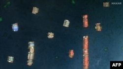 This handout satellite imagery received on March 25, 2021, from Maxar Technologies shows Chinese vessels anchored at the Whitsun Reef, about 320 kilometers (175 nautical miles) west of Bataraza in Palawan in the South China Sea.