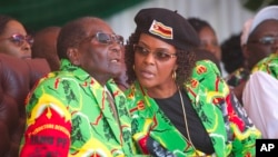 FILE - Zimbabwean President Robert Mugabe and his wife Grace follow proceedings during a youth rally in Marondera about 100 kilometers east of Harare, June, 2, 2017. 