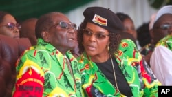 Zimbabwean President Robert Mugabe and his wife Grace follow proceedings during a youth rally in Marondera about 100 kilometers east of Harare, June, 2, 2017. 
