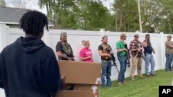This June, 1, 2020, image from video provided by Alissa Murray shows demonstrators protesting police brutality and racism encountering a line of armed bystanders as they march in Crown Point, Ind. 