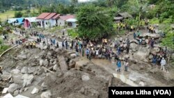 Situasi di desa Bolapapu pascabanjir bandang yang menyisakan tumpukan material batu dan batang kayu yang memenuhi badan sungai dan jalan, serta merusak rumah warga, 13 Desember 2019. (Foto: VOA/Yoanes Litha)