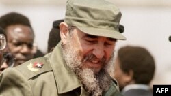 FILE - This photo taken on Aug. 31, 1986 shows Cuban President Fidel Castro (C), flanked by Zimbabwean President Robert Mugabe (L), as he arrives in Harare, for the 8th non-aligned summit in Zimbabwe.