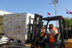 FILE - A container with doses of Russia's Sputnik V vaccine against the coronavirus disease is loaded into a truck, at the airport in Luque, Paraguay, Feb. 18, 2021.