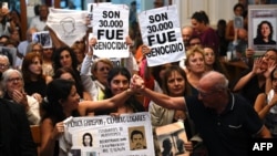 Victoria Moyano Artigas, left, and Pablo Diaz, right, along with relatives of those who suffered abuse during Argentina's military dictatorship celebrate as 12 defendants are sentenced for crimes against humanity in La Plata, Buenos Aires Province, Argentina, on March 26, 2024. 