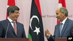 Turkish Foreign Minister Ahmet Davutoglu (L) attends a news conference with Mustafa Abdel Jalil, head of the rebel National Transitional Council, in Benghazi, August 23, 2011