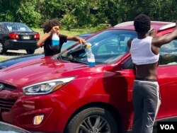 Baltimore’s so-called “squeegee kids” help teenagers make money by washing car windshields as drivers wait at stoplights. (VOA/C. Presutti)