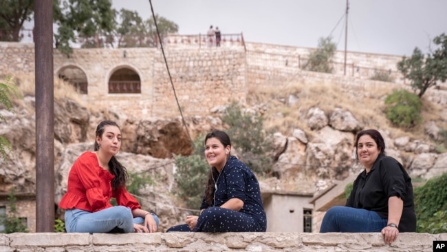 Visitors sit together in Lalish, the Yazidi's most holy temple, in the Shekhan district of the Kurdistan region of Iraq, June 24, 2024.