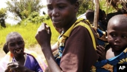 FILE - People return to their village of Rusamambo, near Goma, DRC.