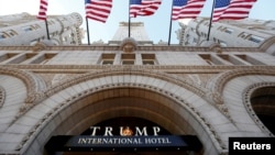 FILE - Flags fly above the entrance to the new Trump International Hotel on its opening day in Washington, D.C., Sept. 12, 2016. 