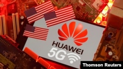 FILE PHOTO: The U.S. flag and a smartphone with the Huawei and 5G network logo are seen on a PC motherboard in this illustratio