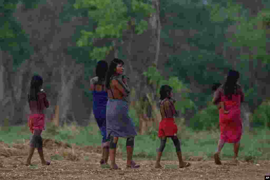 An indigenous family walks on the banks of the Taguarussu River in Palmas, Brazil. Palmas is the host city for the first World Indigenous Games that will showcase traditional sports with the participation of more than 2,000 indigenous athletes from around the world. The event begins Oct. 23 and runs through Nov. 1.