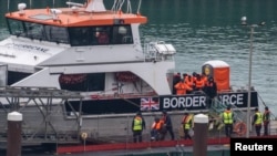 FILE - People believed to be migrants disembark from a British Border Force vessel as they arrive at the Port of Dover, in Dover, Britain, Dec. 29, 2024. 