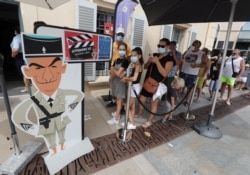 Tourists wearing protective face masks line up to visit the Gendarmerie and Cinema Museum in Saint Tropez as France reinforces mask-wearing as part of efforts to curb a resurgence of the coronavirus disease, Saint Tropez, Aug. 17, 2020.