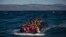 Emigrantes afganos en un sobrecargado bote se aproximan a la isla griega de Lesbos.