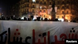 Demonstrators from various anti-military groups shout slogans during a protest against government military rules and against Egypt's Army Chief General Abdel Fattah al-Sisi, at Talaat Harab Square in downtown Cairo, Jan. 22, 2014.