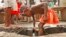 FILE - An Angolan child washes in a ditch near a water pump in Luanda.