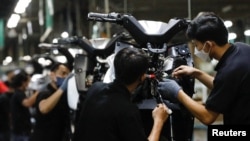 Sejumlah karyawan bekerja di lini produksi di pabrik motor listrik United E-Motor di Bogor, Jawa Barat, pada 25 Agustus 2022. (Foto: Reuters/Ajeng Dinar Ulfiana)