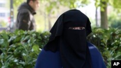一名22岁的女性穿戴遮面面纱坐在比利时布鲁塞尔的公园(资料照片)