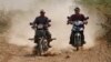 Cambodian farmers drive their motorbike through a dirt road at a remote rural area as they head to work in their farm, near Russey Chroy village, Kandal province, north of Phnom Penh, Cambodia, Tuesday, March 31, 2015. (AP Photo/Heng Sinith)