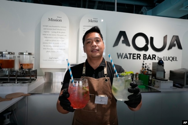 JC, mixologist, presents two types of gourmet water cocktails at the AQUA Water Bar by LUQEL in Dubai, United Arab Emirates on July 11, 2023. (AP Photo/Kamran Jebreili)