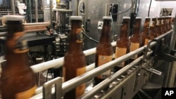 FILE - Bottles freshly filled with beer move on a conveyor belt at Lakefront Brewery in Milwaukee, Wisconsin, on Jan. 14, 2019.