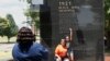 Katrina Cotton, centro de Houston, posa para una foto con su hija, Kennedy Cotton en el memorial de Black Wall Street en Tulsa, Oklahoma.