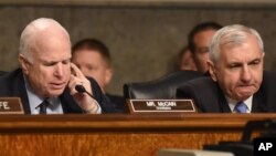 Senate Armed Services Committee Chairman John McCain, R-Ariz., left, accompanied by the committee's ranking member, Sen. Jack Reed, D-R.I., speaks during a committee meeting on Islamic State, on Capitol Hill in Washington, Oct. 27, 2015. 