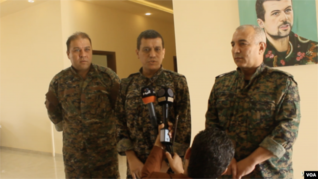 资料照片：叙利亚民主军总指挥官马祖卢姆·阿比迪(中)在叙利亚科巴尼的一次记者会上讲话。(2019年7月22日)
