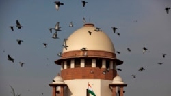 FILE- Merpati terbang melewati kubah gedung Mahkamah Agung India di New Delhi, India, 2 Februari 2016.