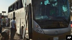 Officials jack up a bus that was damaged by a bomb, in Cairo, Egypt, Sunday, March 19, 2019. Egyptian officials say a roadside bomb has hit a tourist bus near the Giza Pyramids.