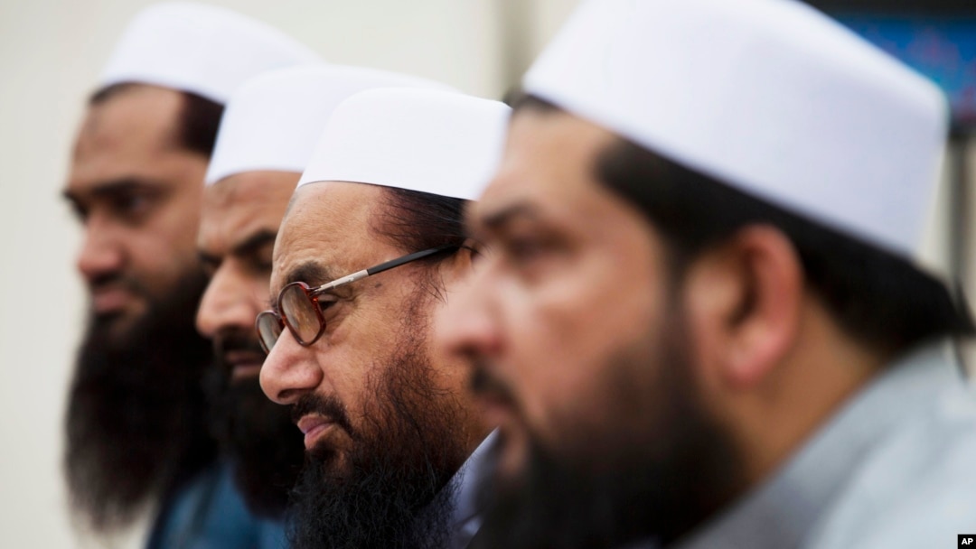 FILE - Hafiz Saeed, second from right, chief of Pakistani religious group Jamaat-ud-Dawa listens to reporters at a news conference in Islamabad, Pakistan, Nov. 2, 2015.
