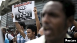 FILE - An Eritrean refugee holds a placard during a protest against the Eritrean government outside their embassy in Tel Aviv, Israel May 11, 2015.