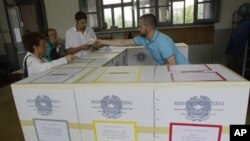 Voters prepare to cast their ballots in Milan, Italy, Sunday, June 12, 2011