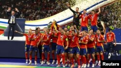 El español Álvaro Morata levanta el trofeo mientras celebran después de la victoria ante Inglaterra, en la final de la Eurocopa 2024.