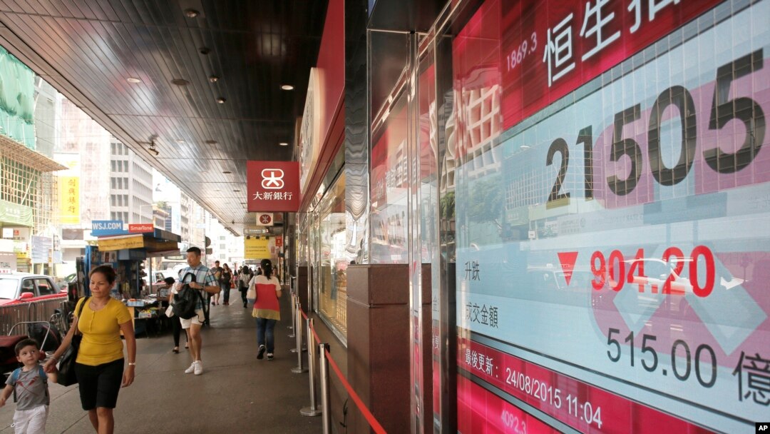 Papan indeks saham Hong Kong di sebuah bank lokal di Hong Kong (24/8). (AP/Vincent Yu)