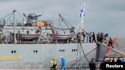 Russian sailors training on Mistral-class amphibious assault ships walk near the Russian navy frigate Smolny at Saint-Nazaire shipyard in western France June 30, 2014.