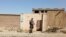 A Taliban solider stands guard in front of a house neighboring the Islamic State hideout raided by Taliban forces on Sunday night in northern Kabul, Afghanistan Oct. 4, 2021.