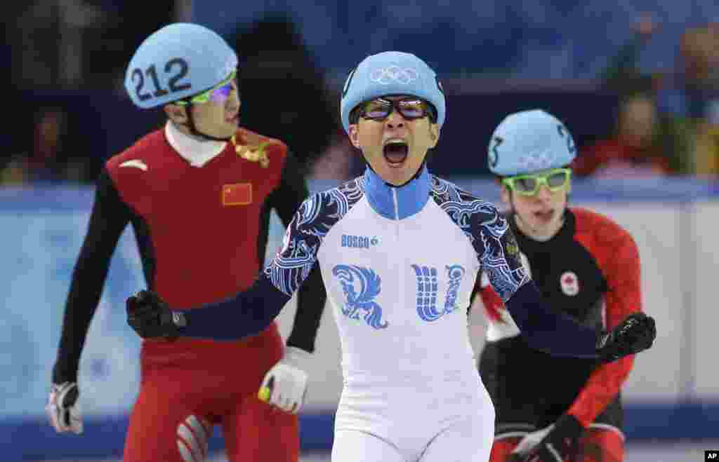 Victor An of Russia reacts as he crosses the finish line ahead of Wu Dajing of China and Charle Cournoyer of Canada in the men's 500m short track speedskating final at the Iceberg Skating Palace, Feb. 21, 2014.