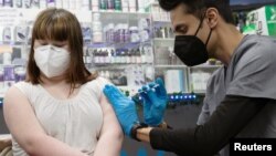 FILE - Lauren Borenstein, 16, receives the Pfizer-BioNTech vaccine against the coronavirus disease at Skippack Pharmacy in Schwenksville, Pennsylvania, March 3, 2021. 