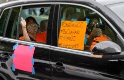 FILE - IMotorists take part in a caravan protest in front of Senator John Kennedy's office at Hale Boggs Federal Building asking for the extension of the $600 in unemployment benefits to people out of work, in New Orleans, La., July 22, 2020.