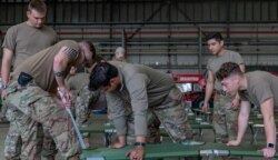 U.S. Air Force Airmen prepare cots at a hangar to provide temporary lodging for qualified evacuees from Afghanistan as part of Operation Allies Refuge, at Ramstein Air Base, Germany, August 19, 2021.