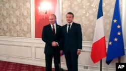 French President Emmanuel Macron, right, and Russian President Vladimir Putin pose for a photo during a meeting on the sidelines of the G-20 summit in Osaka, Japan, June 28, 2019. 