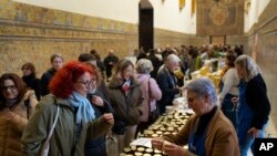 FILE - Customers buy marmalades and cakes made by cloistered nuns, at a market at the Reales Alcazares in Seville, Spain, on December 5, 2023.