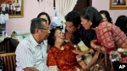 Family members comfort Chrisman Siregar, left, and his wife Herlina Panjaitan, the parents of Firman Siregar, one of the Indonesian citizens registered on the manifest to have boarded the Malaysia Airlines jetliner flight MH370 that went missing over the 