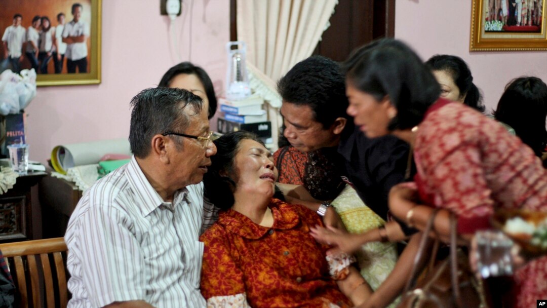 Para anggota keluarga menenangkan Chrisman Siregar (kiri) dan istrinya Herlina Panjaitan, orangtua Firman Siregar, penumpang pesawat Malaysia Airlines yang hilang asal Indonesia. (AP/Binsar Bakkara)
