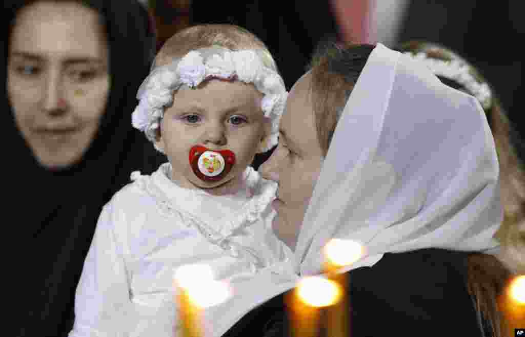 A woman holds a child during an Orthodox Christmas Mass at the Christ the Saviour Cathedral in Moscow, January 7, 2012. Russia celebrates Christmas on January 7 according to the Julian calendar that is used by the country's Orthodox church. (Reuters)