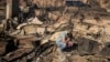 Luke Dexter kneels as he sifts through the remains of his father's fire-ravaged beachfront property in the aftermath of the Palisades Fire on Jan. 10, 2025, in Malibu, California.